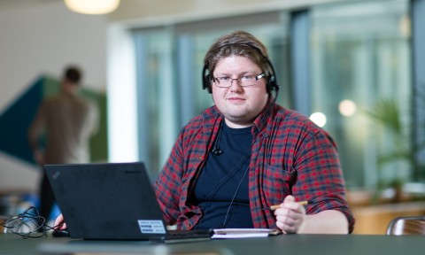 man behind desk looking into camera